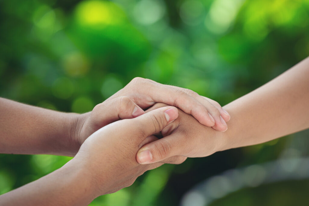 couple-holding-hands-green-meadow